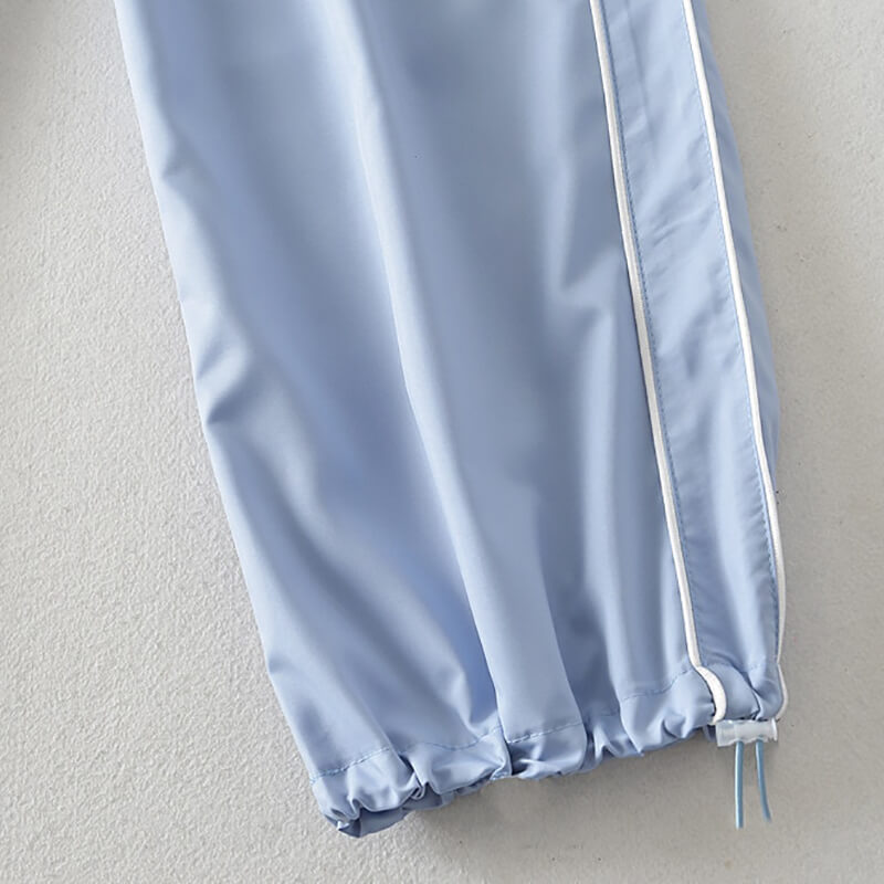 Light blue high-waisted sweatpants with white side stripe and elastic cuffs, polyester fabric, designed for women, SF1031.