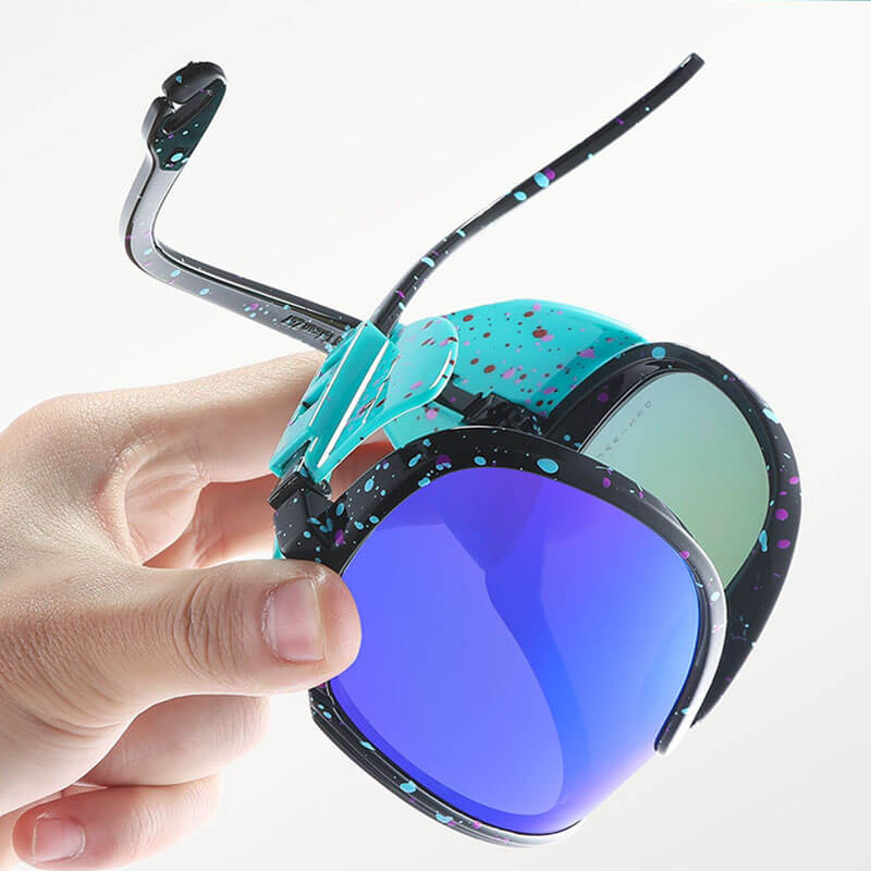 Close-up of a hand holding SF0963 polarized anti-reflective sports sunglasses with blue-lens and vibrant speckled plastic titanium frame.