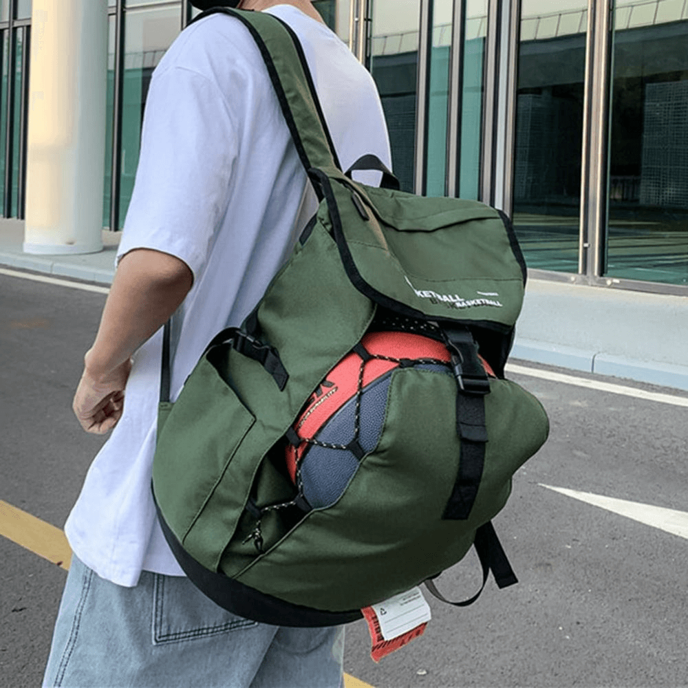 Person carrying a green sports backpack with a ball pocket, showcasing basketball storage functionality and adjustable straps.