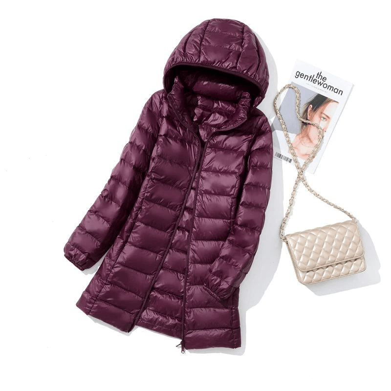 Maroon puffer jacket with detachable hood and double zipper, styled with quilted purse and magazine for a chic winter look.