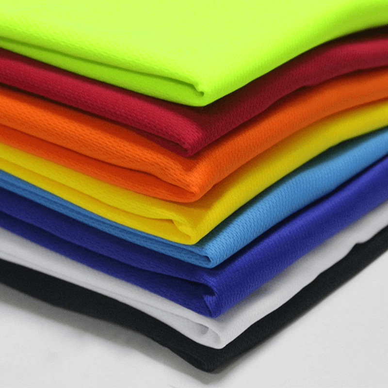 Stack of colorful quick-drying polyester fabrics for men's sportswear.