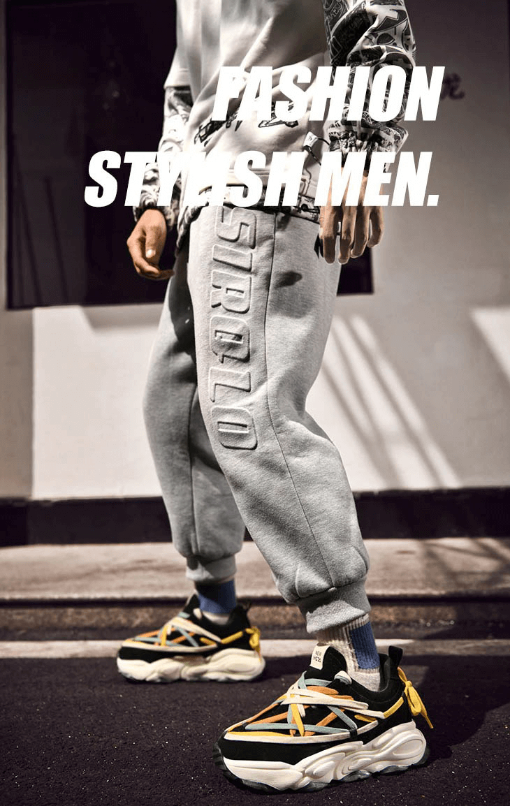 Man wearing fashionable running thick bottom leather sneakers with colorful laces and gray sweatpants, text 'Fashion Stylish Men' overlayed.