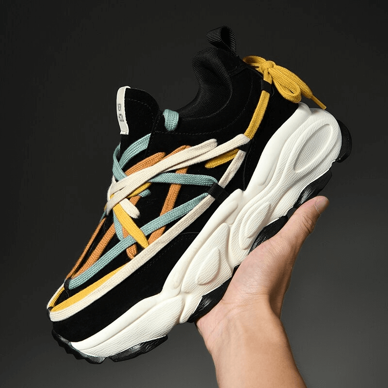 Hand holding a stylish running sneaker with thick bottom and multicolored laces, perfect for stability and performance. SF0375.