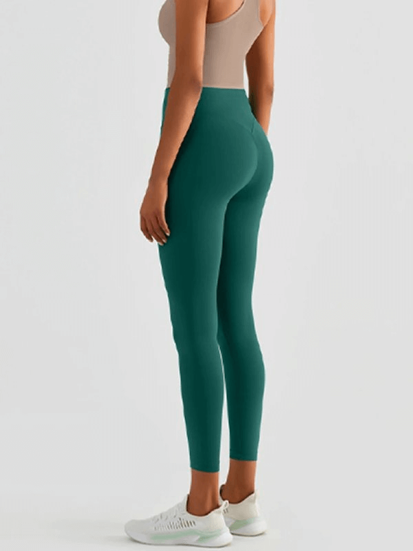 Woman wearing green seamless breathable fitness leggings, side view. Ideal for yoga, flexible fit, nylon and spandex blend.
