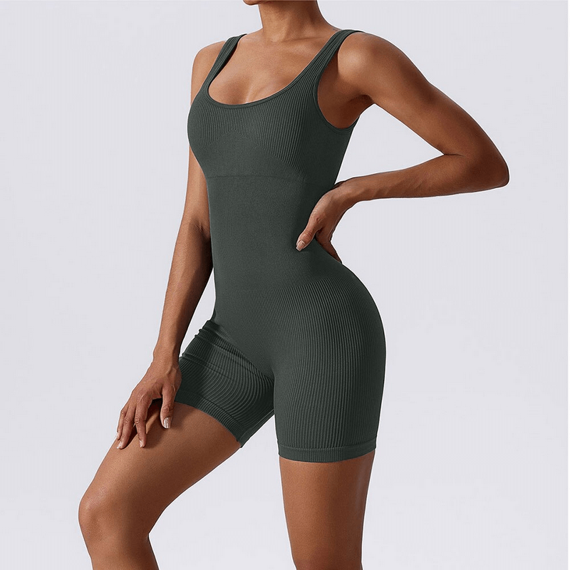 Woman wearing seamless one-piece short yoga suit for sports and fitness, featuring breathable and quick-dry fabric in dark color.