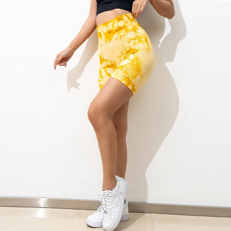 Woman wearing seamless sports scrunch butt shorts in yellow, showcasing high-waist and slim fit, perfect for yoga or workouts.
