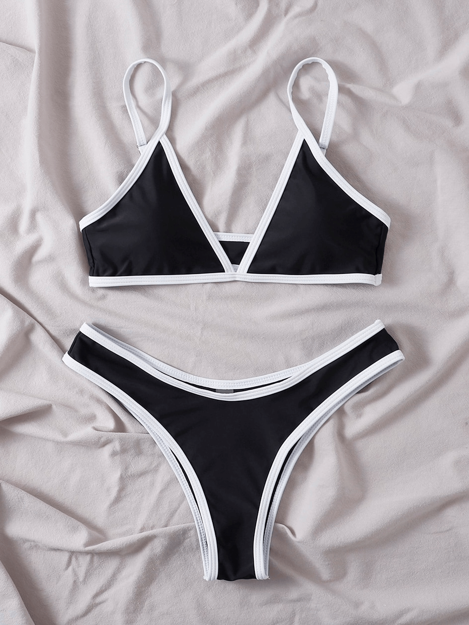 Sexy black micro bikini set with adjustable straps on fabric background, perfect for beachwear. Stylish and comfortable swimwear.