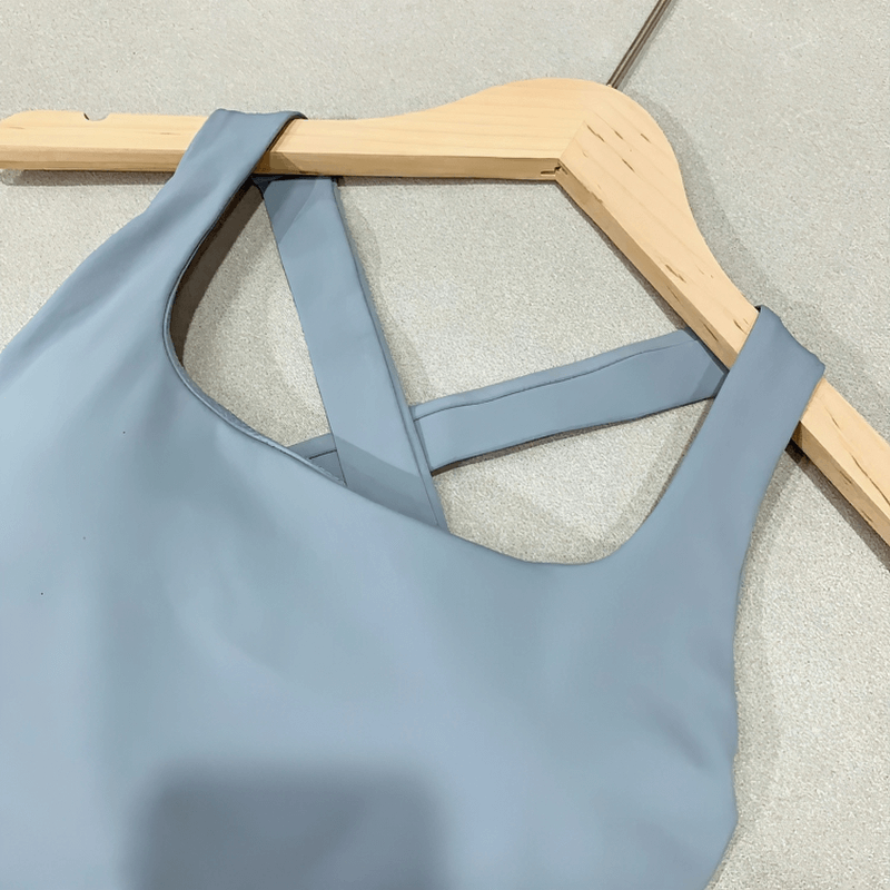 Sexy Cross Back Running Tank Top in blue on hanger, Nylon and Spandex blend, designed for women's training and high-intensity workouts.