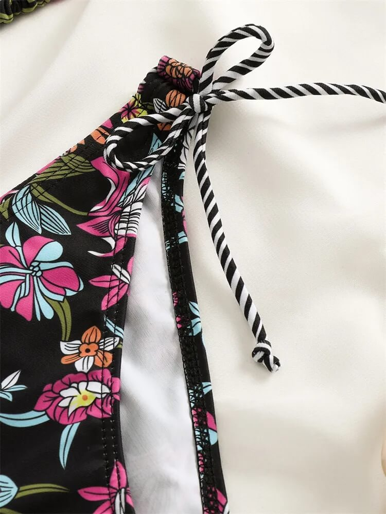 Close-up of floral print bikini with striped tie, showcasing vibrant colors and stylish design for a sexy beach look.
