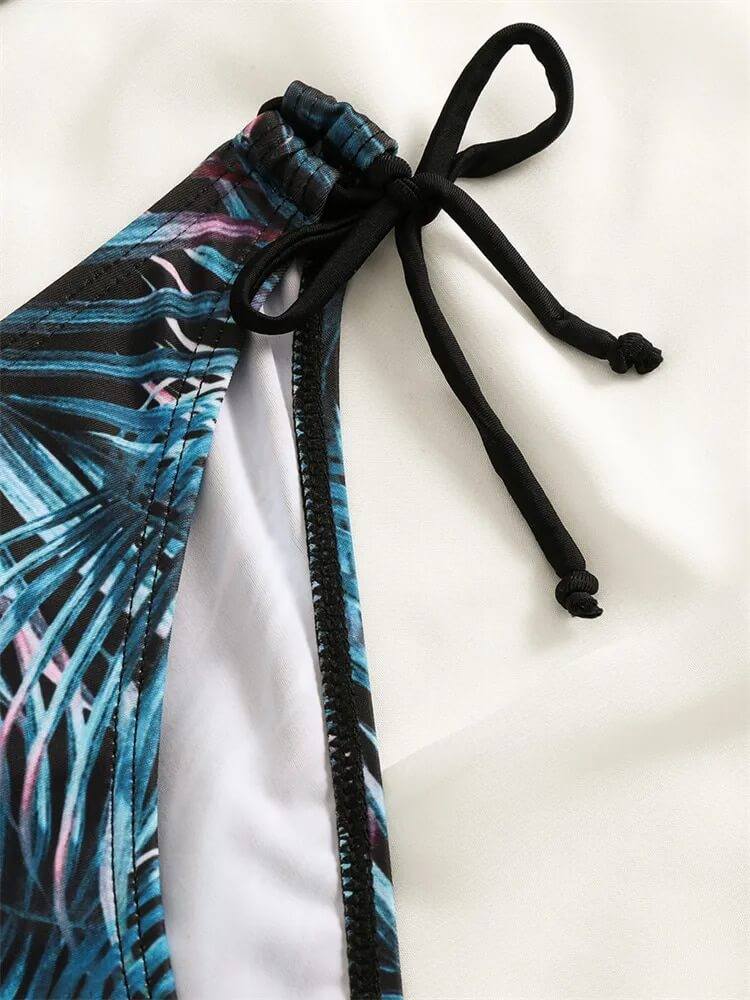 Close-up of printed bikini tie detail with blue and black palm pattern for a stylish beach look.