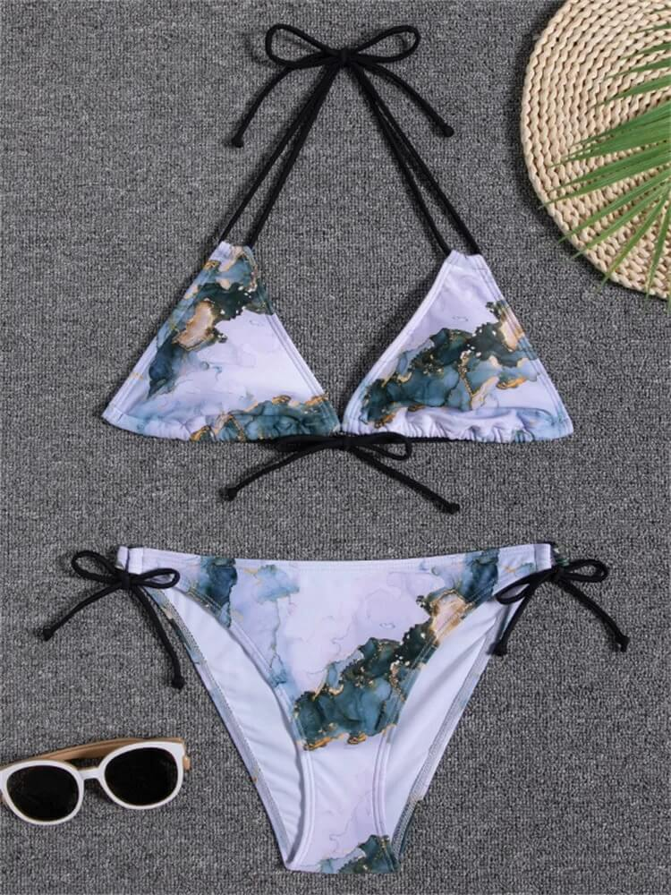 Stylish two-piece bikini with print design and low waist, perfect for beachwear, paired with sunglasses and a straw hat.