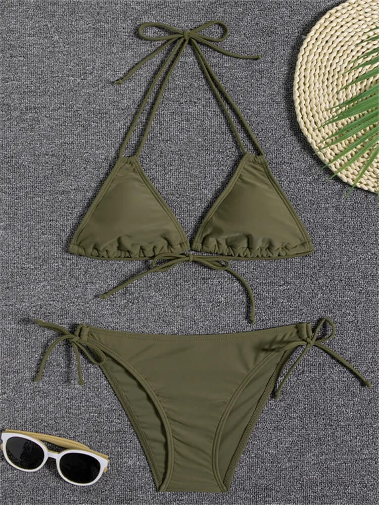 Olive green two-piece swimsuit with ruffle trim and tie-up design, lying flat with sunglasses and straw hat nearby.