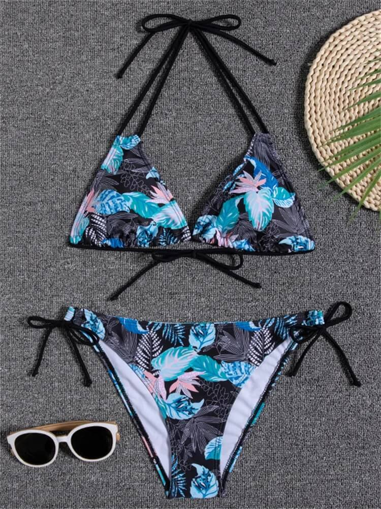 Tropical floral print bikini set with low waist, stylish for beach days. Includes a bikini top and bottoms alongside sunglasses and hat.