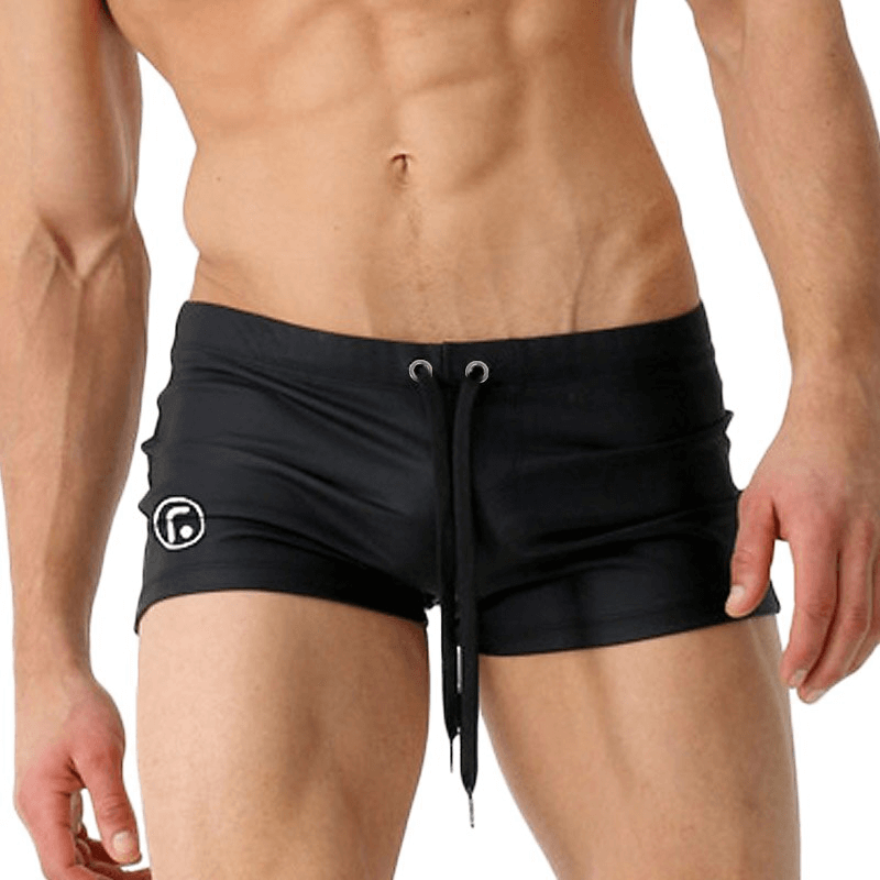 Men's black drawstring swimming trunks, stylish and flexible, perfect for beach or pool. Solid color, snug fit in nylon-spandex blend.