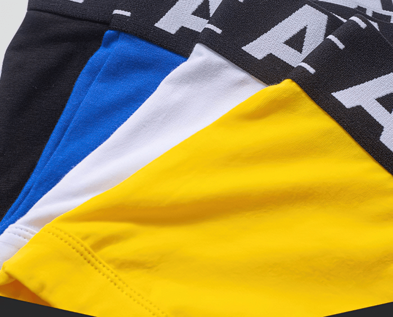 Colorful selection of breathable cotton-spandex male panties in black, blue, white, and yellow, featuring a stylish letter pattern waistband.