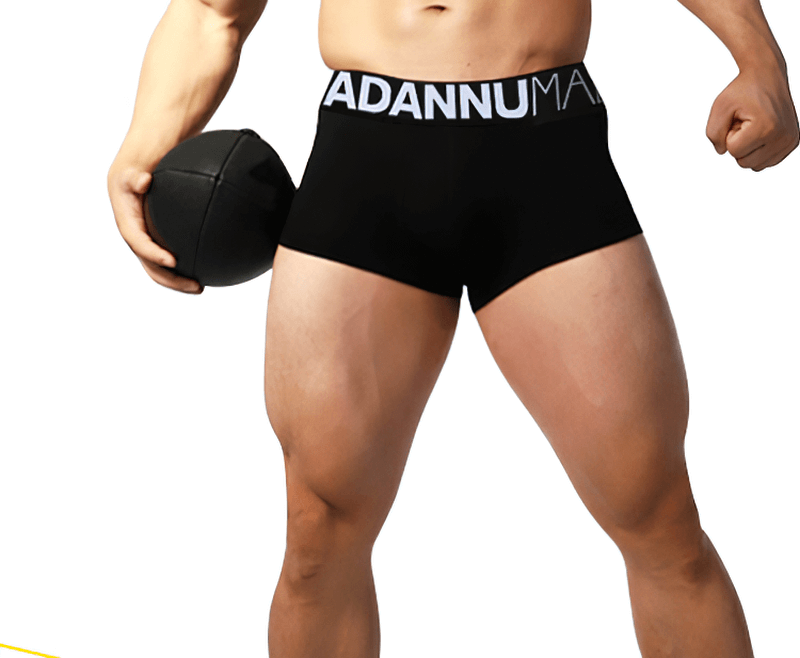 Model wearing sexy soft breathable male panties with bold lettering, showcasing sporty black cotton underwear for comfort and style.