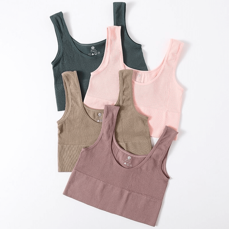Stack of ribbed seamless tank tops in pink, brown, and green, ideal for yoga, fitness, and dance. Comfortable sportswear for women.