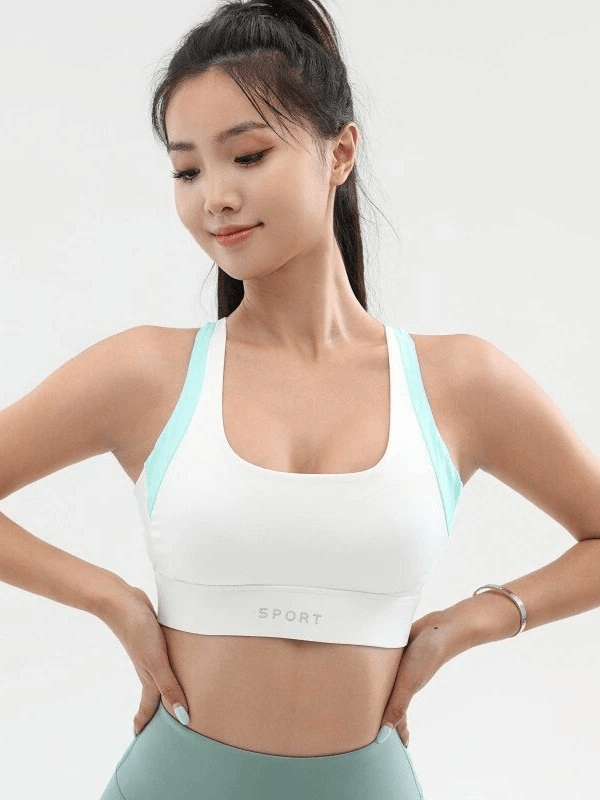 Woman wearing sexy white sports top with push-up effect, ideal for workouts, featuring breathable material and rear buckle closure.