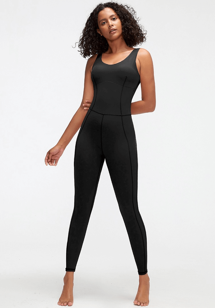 Woman wearing black one-piece elastic yoga jumpsuit, ideal for fitness or sports.
