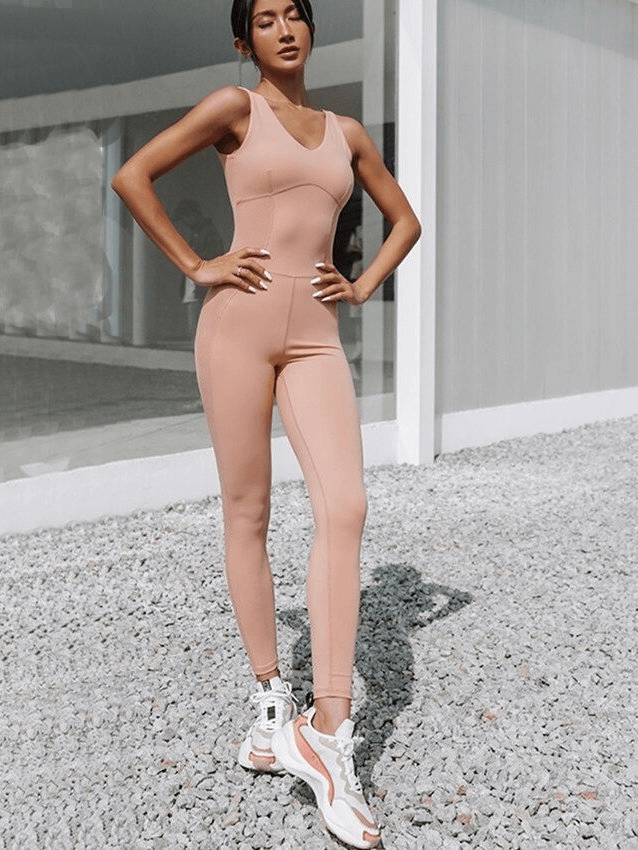Stylish women's fitness jumpsuit in nude pink, perfect for yoga or sports. High-quality, breathable, and elastic one-piece suit.