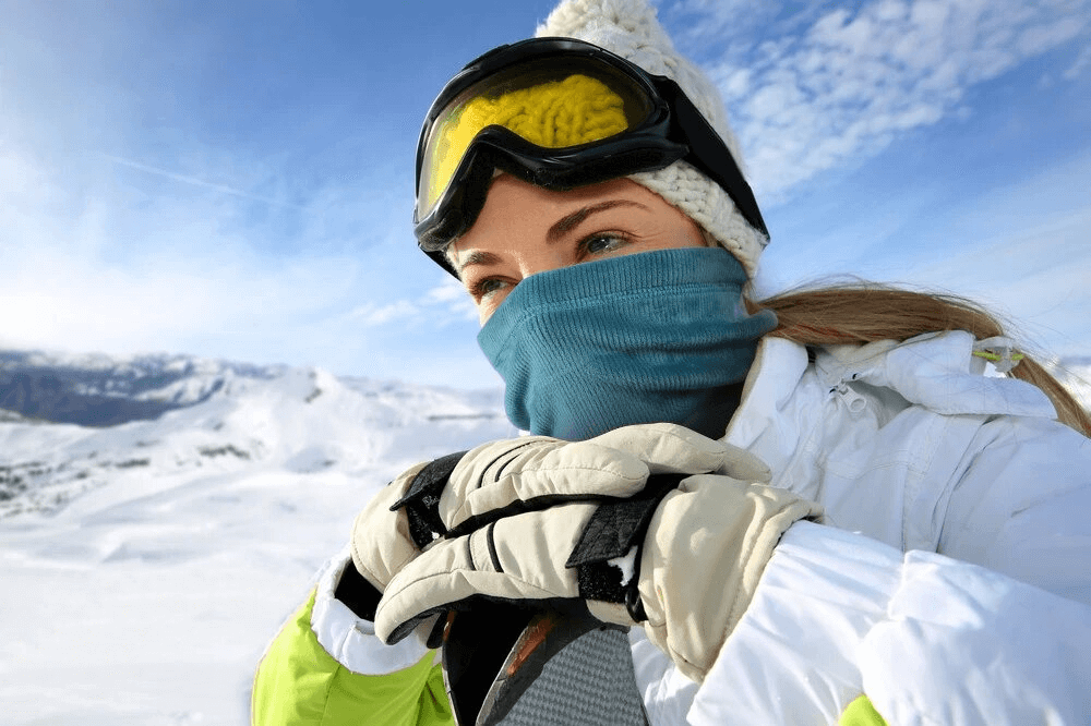 Person wearing a Skiing Thermal Corduroy Elastic Scarf and goggles in snowy mountains, showcasing winter sports gear.