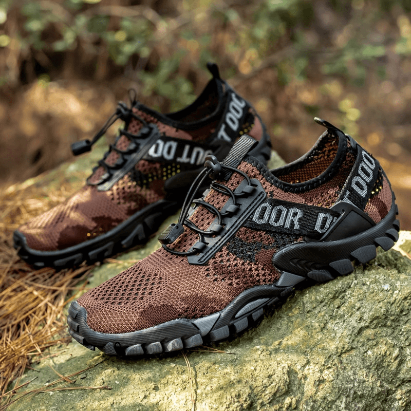 Brown breathable non-slip trekking sneakers for men on a rock, featuring a mesh upper and rugged outsole, perfect for hiking.