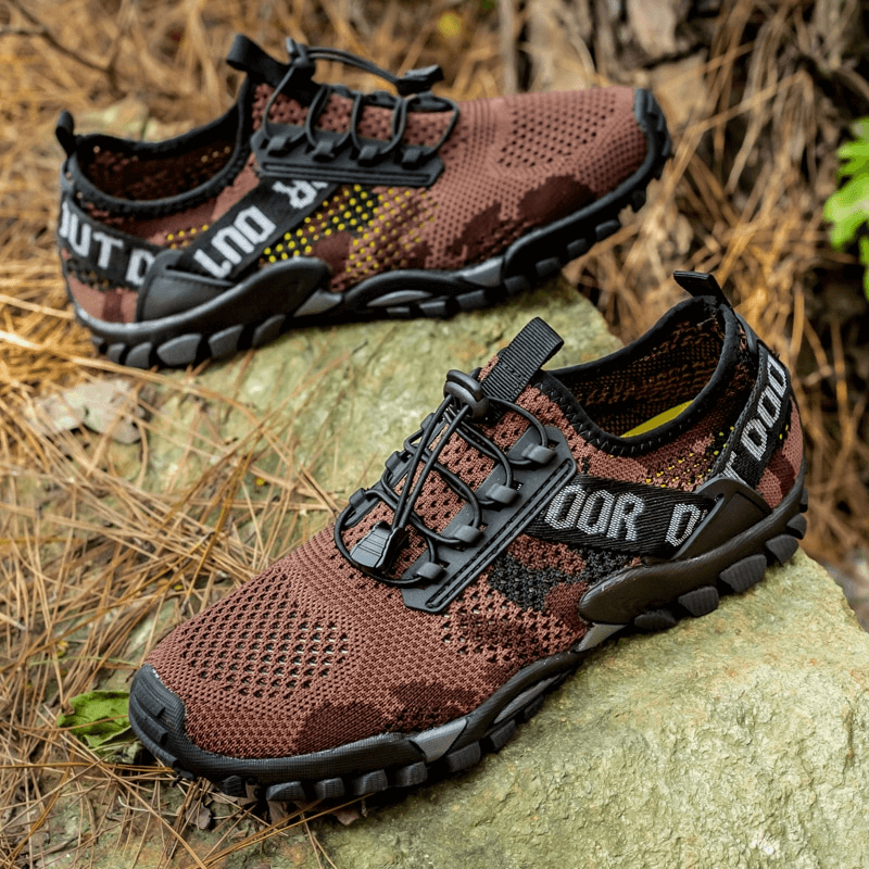 Soft breathable men's trekking sneakers with non-slip soles on rocky trail, perfect for outdoor adventures.