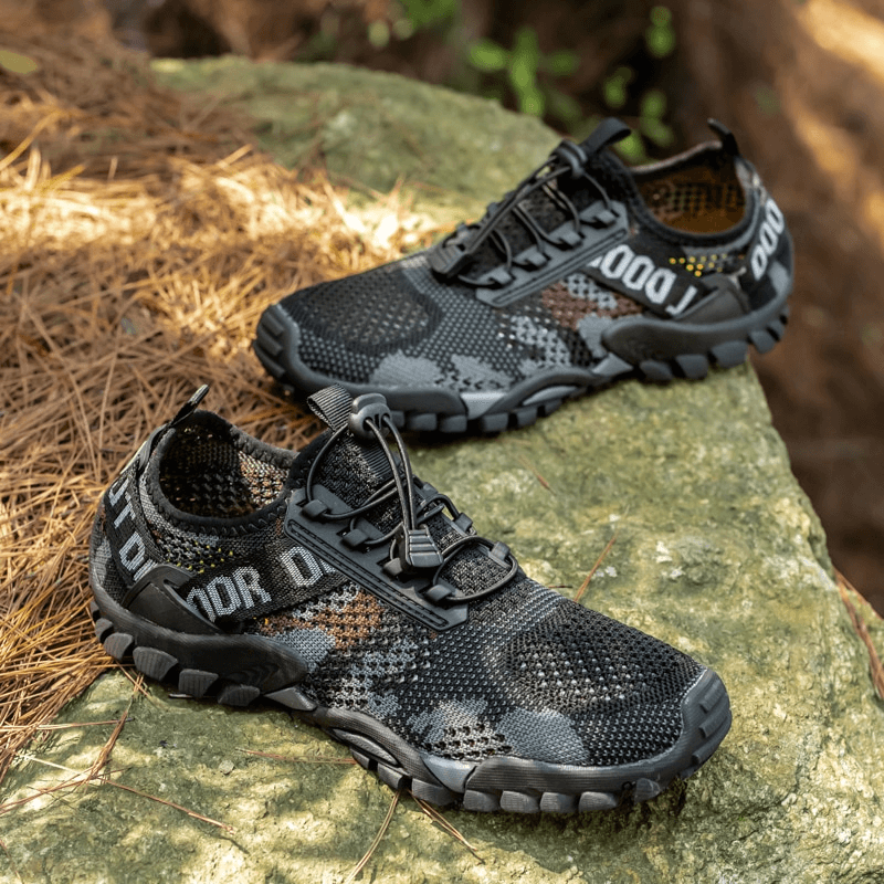 Men's breathable non-slip trekking sneakers with rubber outsole, perfect for hiking. Features mesh upper, lace-up closure on rocky terrain.