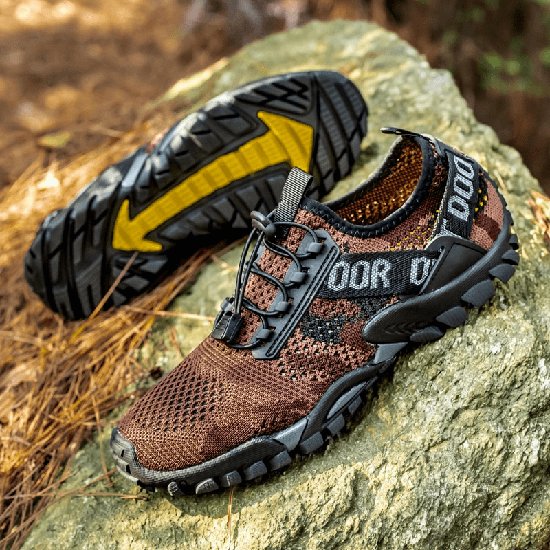 Men's soft breathable non-slip trekking sneakers with rubber outsole on a rock, ideal for hiking and outdoor sports.