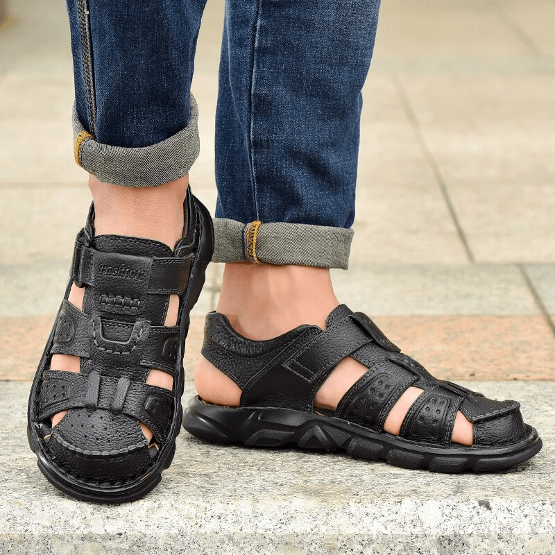 Man wearing Soft Soles genuine leather trekking sandals with anti-collision toes, featuring adjustable hook & loop closure and rubber outsole.