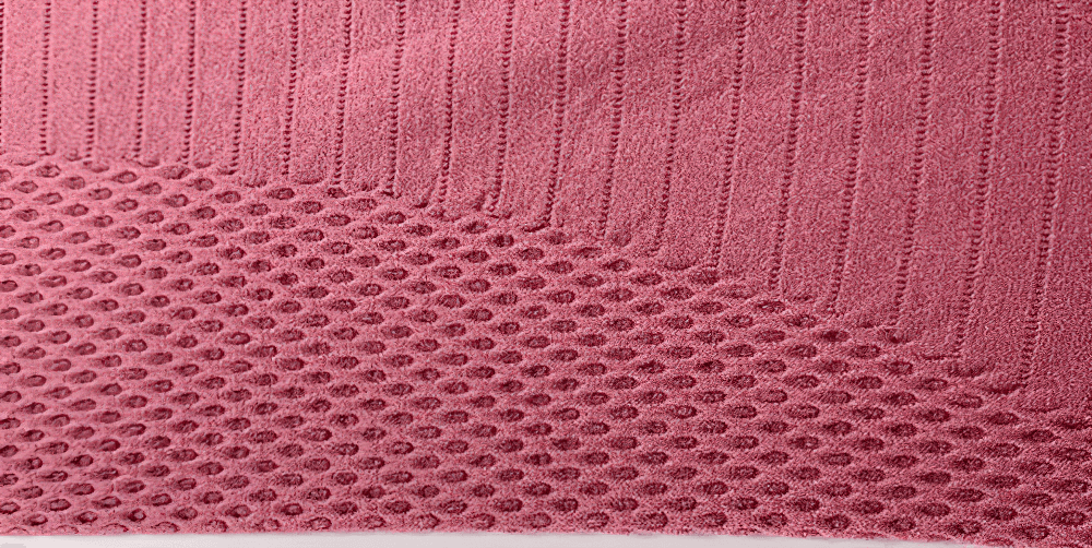 Close-up of textured nylon fabric in pink, perfect for quick-drying sportswear like yoga T-shirts for women.