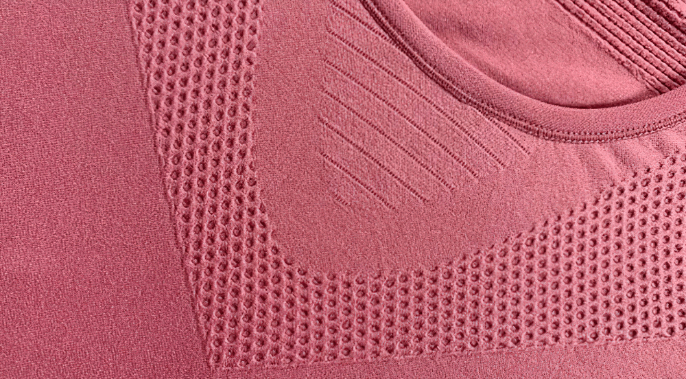 Close-up of a pink textured fabric on a quick-drying sports short-sleeved t-shirt for women. Ideal for yoga and outdoor activities.