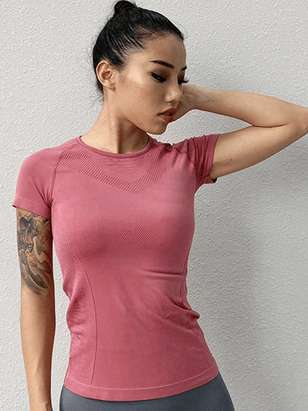Woman wearing a pink solid color quick-drying short-sleeve sports t-shirt, ideal for yoga and outdoor activities.