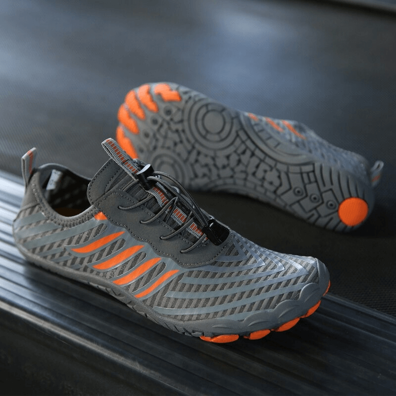 Gray sports sneakers with orange accents, featuring anti-slip soles and drainage holes for active lifestyle comfort.