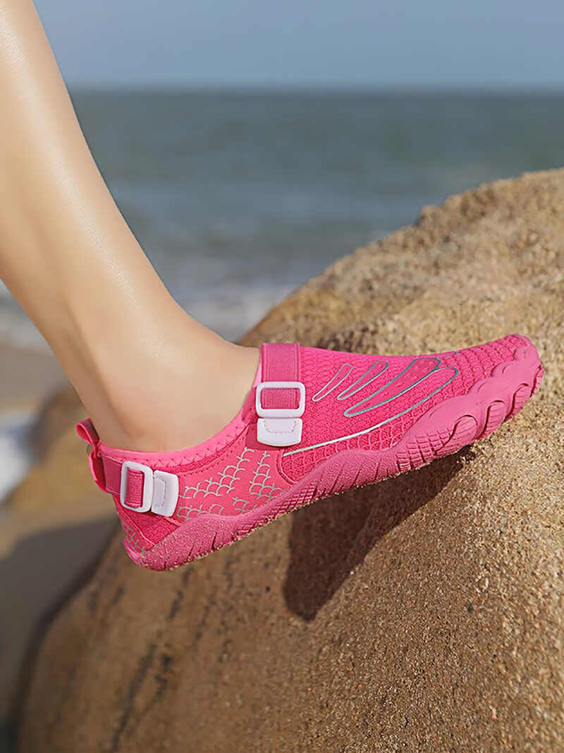 Pink unisex aqua shoe on a rock, perfect for swimming and outdoor activities, with synthetic upper and TPR outsole.