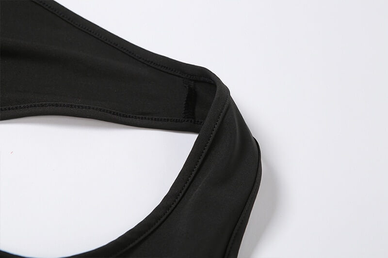 Close-up view of black asymmetrical elastic high-waist romper for women, showcasing sporty, slightly stretchable fabric texture.