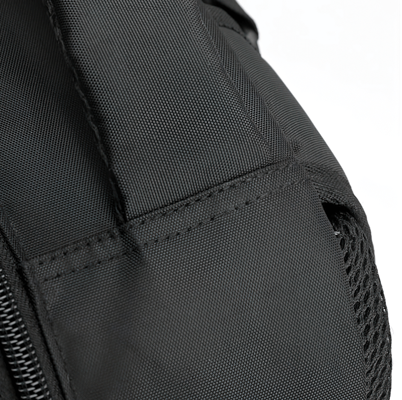 Close-up of black sports backpack with sturdy fabric and net pocket detail, ideal for gym and sports activities.