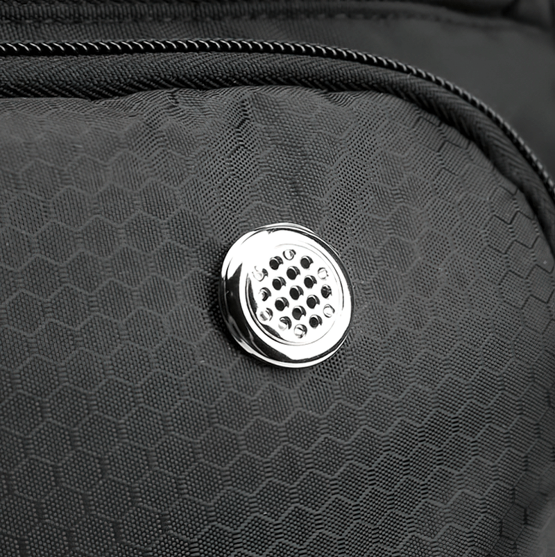 Close-up of black sports backpack with silver vent detail, showcasing durable waterproof material and hexagon pattern.