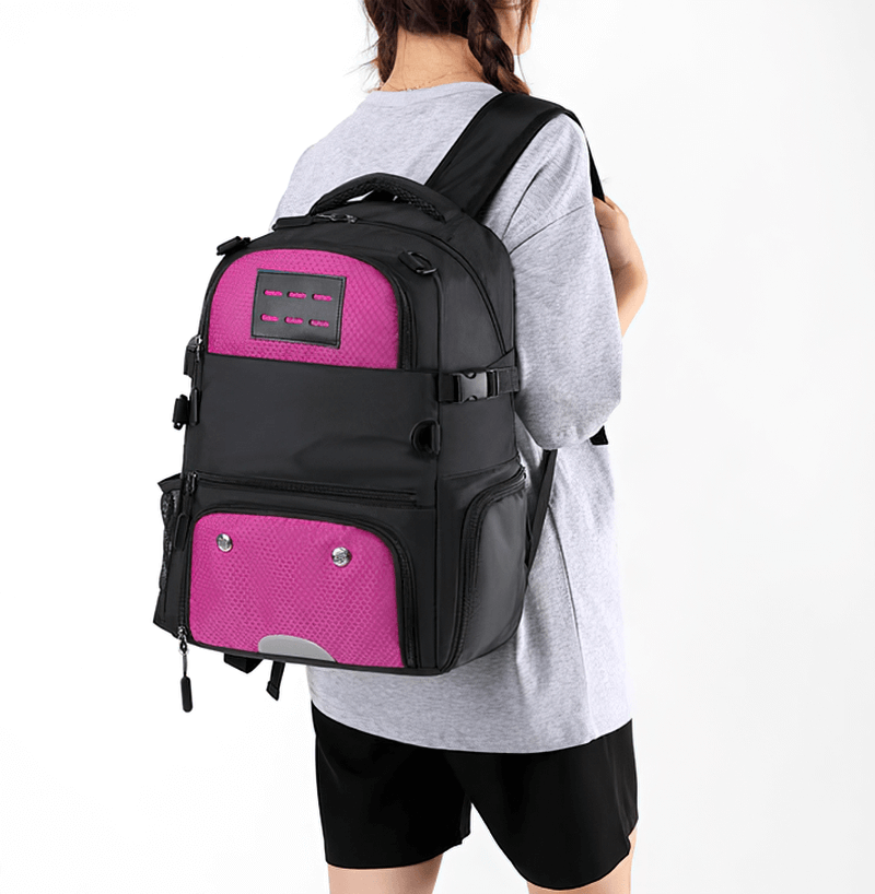 Unisex sports backpack with pink accents, featuring a shoe compartment, detachable net pocket, waterproof material, worn by a person.