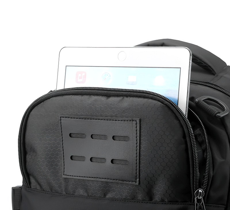 Black sports backpack with a laptop partially visible inside, showing the front zipper pocket and durable material.
