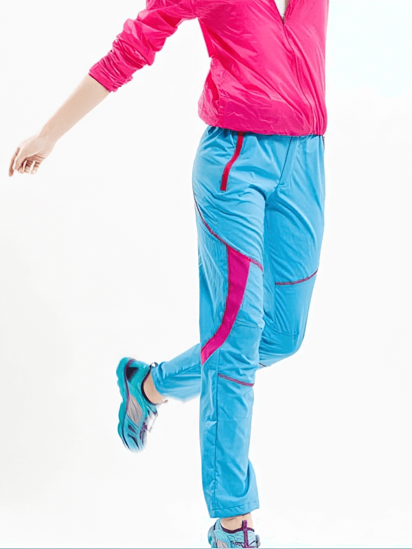 Woman modeling blue sports breathable quick-drying hiking pants with pink accents, perfect for outdoor adventures.