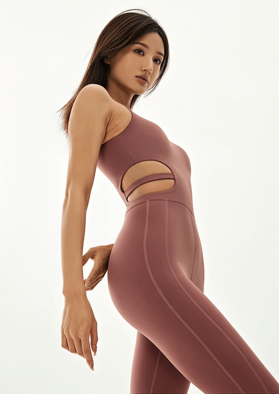 Model wearing sports elastic one-piece women's sleeveless yoga jumpsuit, showcasing comfort and flexibility in stylish mauve design.