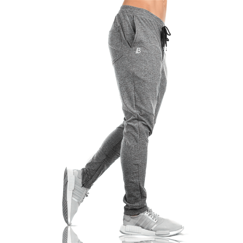 Model wearing grey Sports Elastic Quick-Drying Men's Pants with Pockets, highlighting breathable fabric and sleek design SF1117.