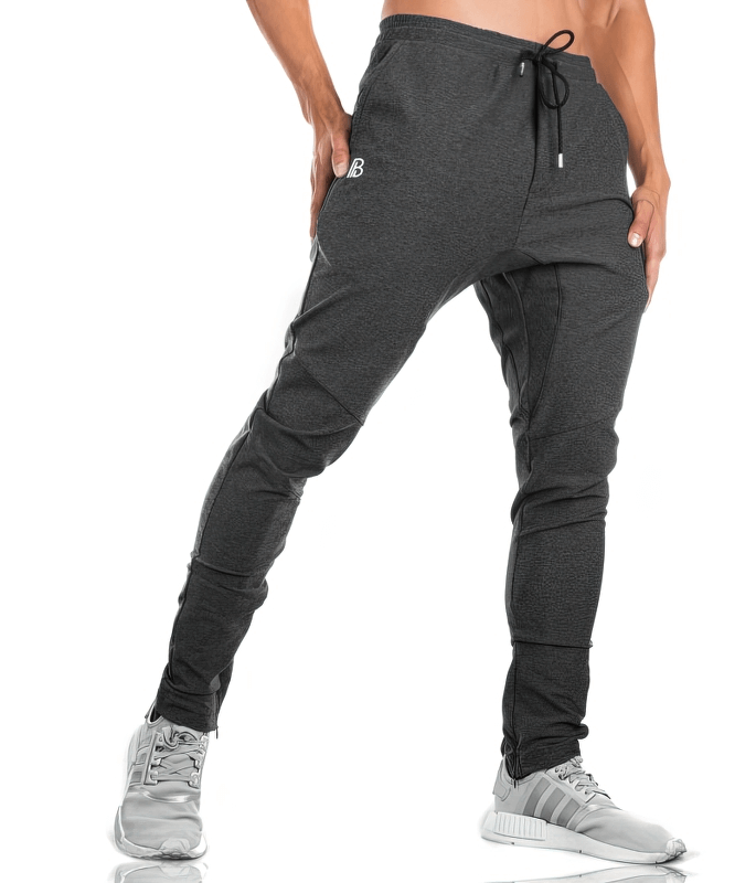 Man wearing black sports elastic quick-drying men's pants with pockets, showing full-length fit and drawstring closure.