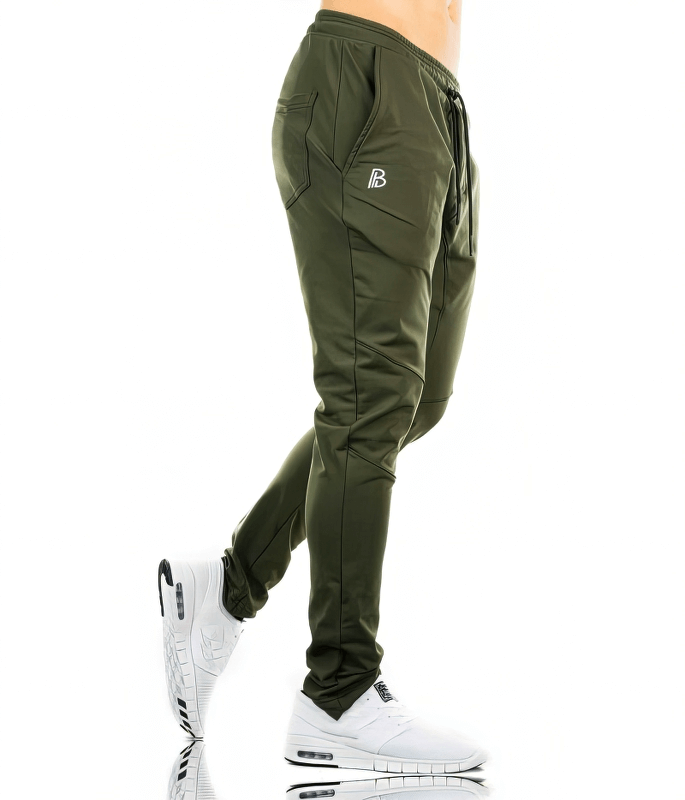Side view of green sports elastic quick-drying men's pants with pockets, SF1117, featuring a sleek design and white sneakers for active style.