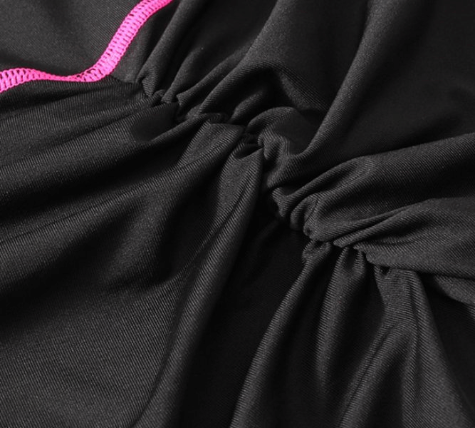 Close-up of black sports elastic fabric with pink trim, showing the material's stretch and texture.