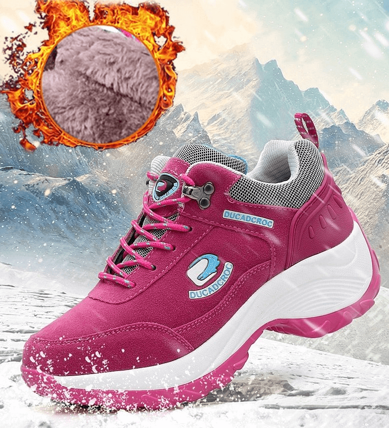 Sporty pink fur-insulated women's sneakers with suede finish, animal print, and mid-heel, set against a snowy mountain background.