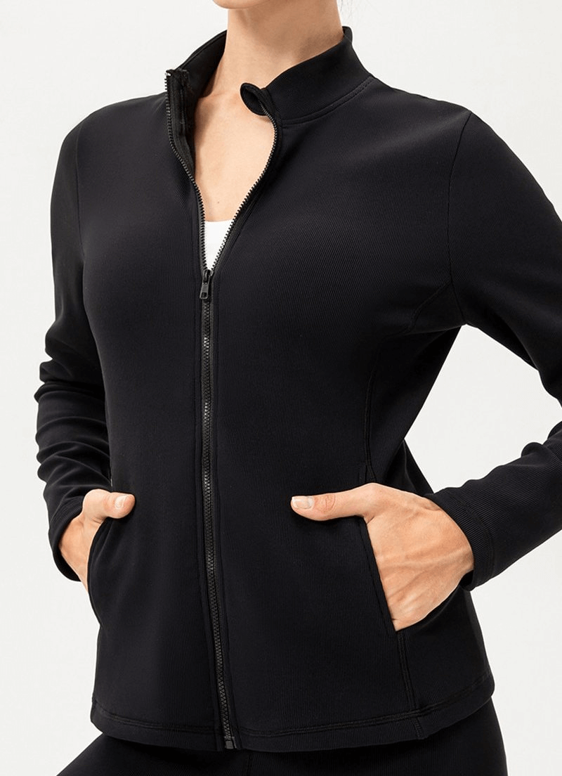 Black sports insulated women's jacket with fleece-lined zipper, high collar, and thumb holes for wind protection.