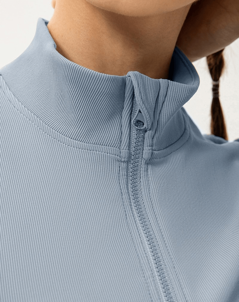 Close-up of a women's sports insulated jacket with a fleece-lined high collar and zipper, model SF0902 in light blue.