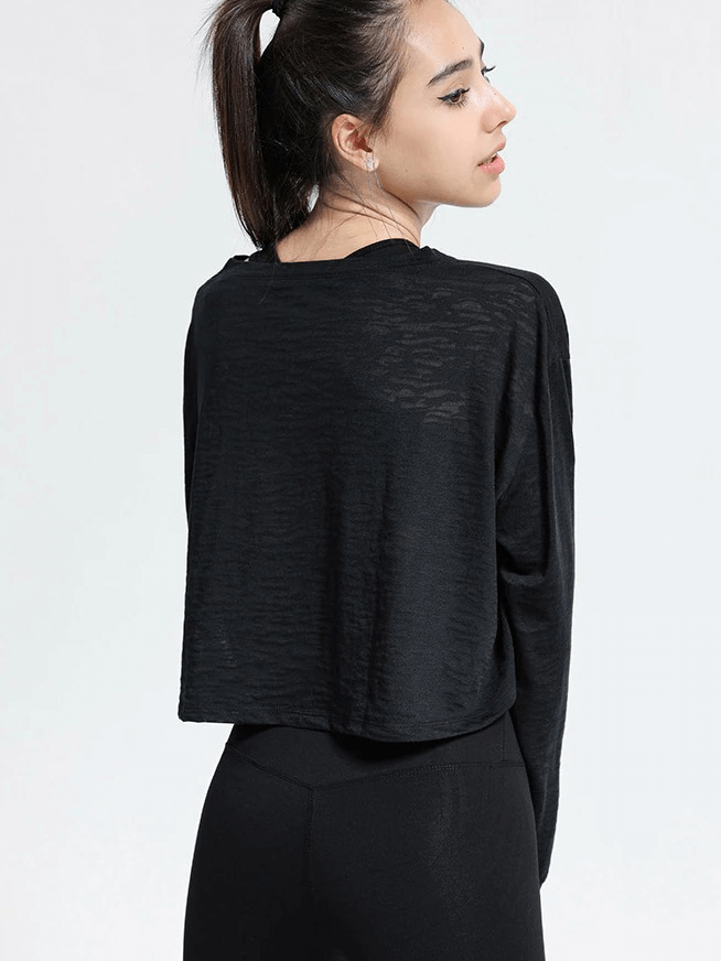 Back view of a woman wearing a black sports long-sleeved loose top, ideal for fitness activities like yoga and running in breathable fabric.